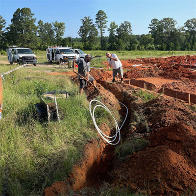 New construction site with ground dug up for plumbing pipes in Shreveport, LA.